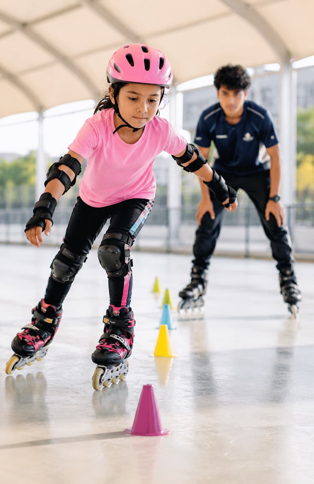 Young skater practicing cone drills with her coach at Blaster Sports Center Qatar